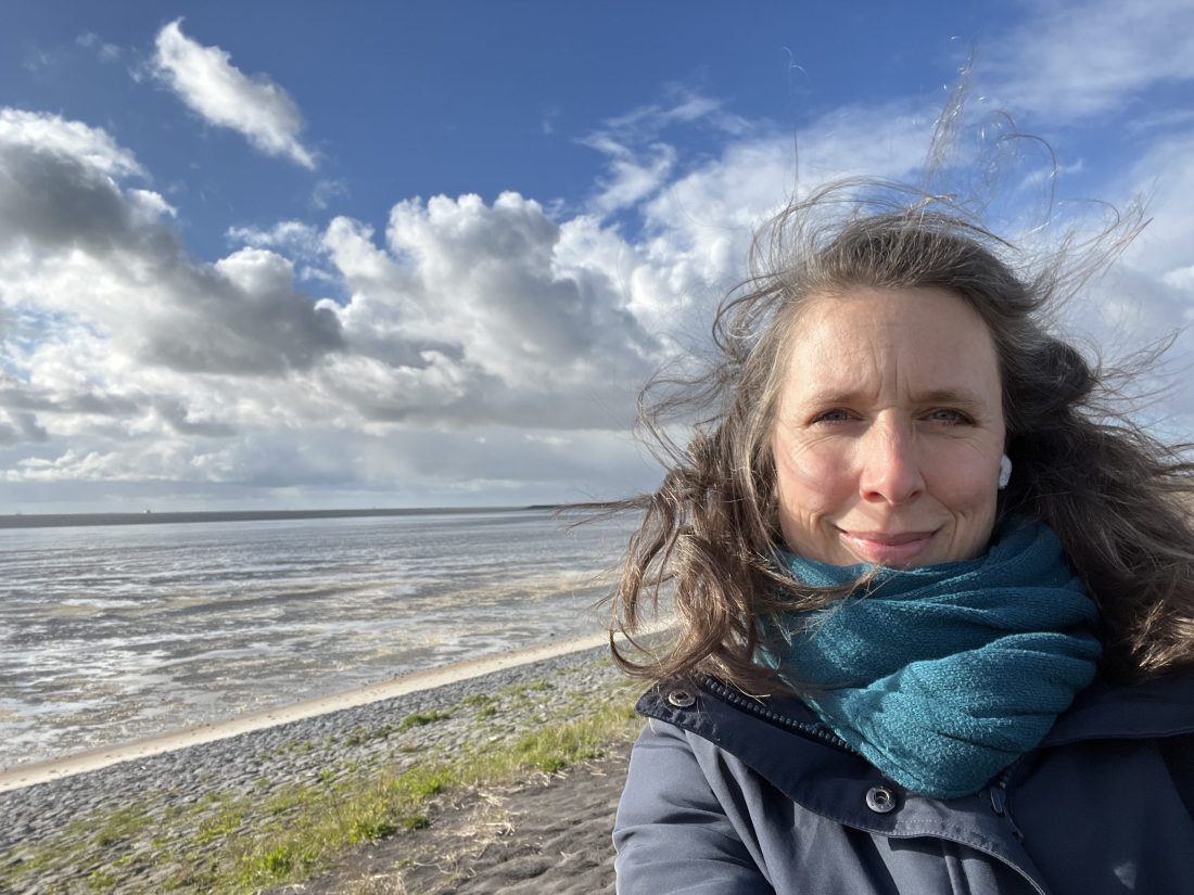 Foto van Linda van den Berg die bij de Waddenzee staat